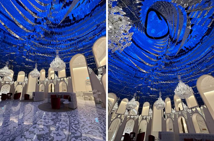 Luxurious interior with reflective blue ceiling, chandeliers, and elegant seating showcasing incredible reality design.