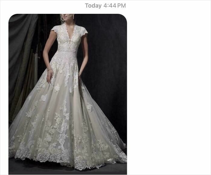 Woman in a detailed lace wedding dress standing against a dark background, showing entitled fashion style of family members.