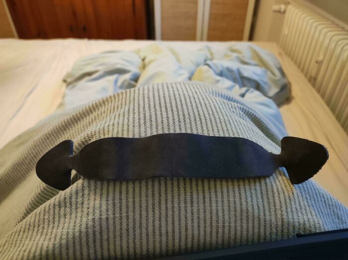 Unidentified metal object with two arrow-shaped ends resting on striped fabric, solved by internet mystery experts.