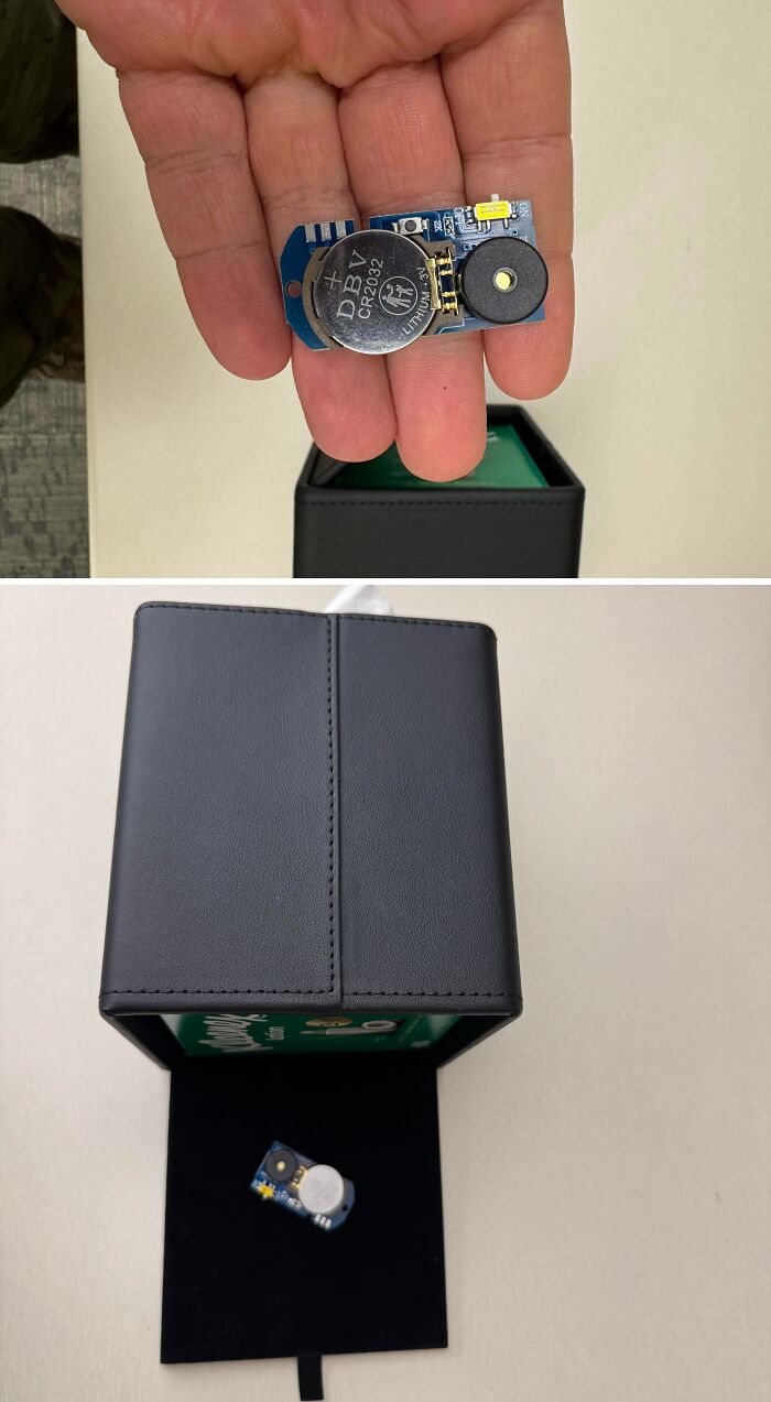 Small electronic component with battery held in hand and placed inside a black box, mystery of unidentified objects solved.