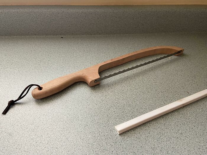 Unidentified object with a wooden handle and serrated blade resting on a countertop, mystery solved by internet users.