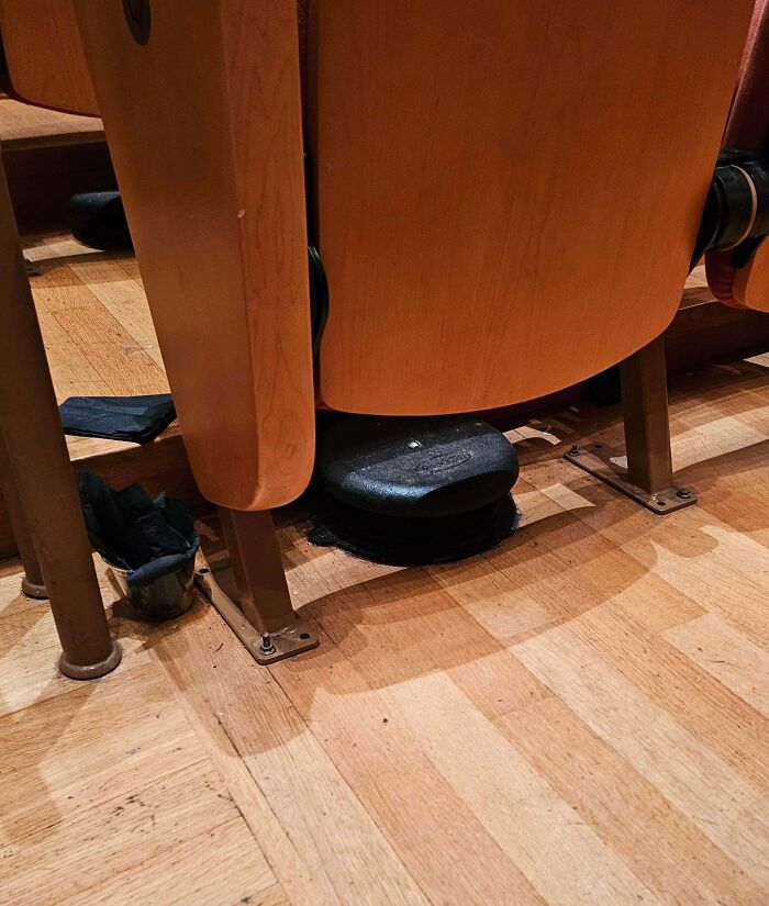Black object hidden under a theater seat revealed as a footrest in a mystery of unidentified objects solved by the internet.