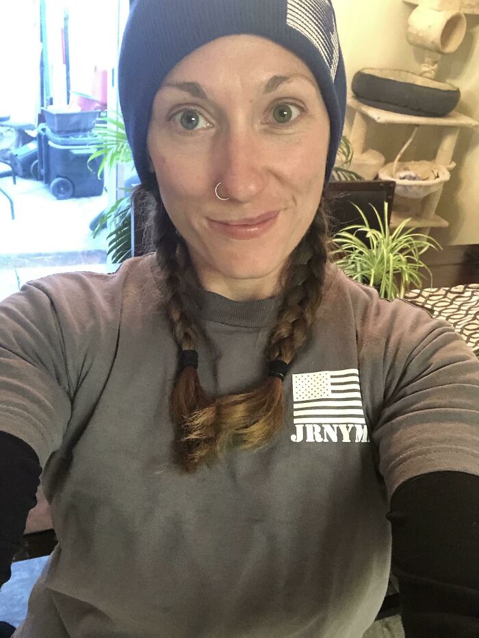 Woman with braided hair and a nose ring wearing a beanie and casual clothes representing women in power tools and lab coats.