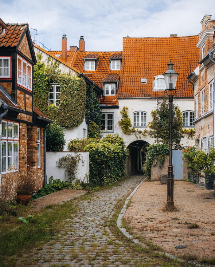 A quaint European cobblestone alleyway evoking an accidental Renaissance aesthetic with historic charm