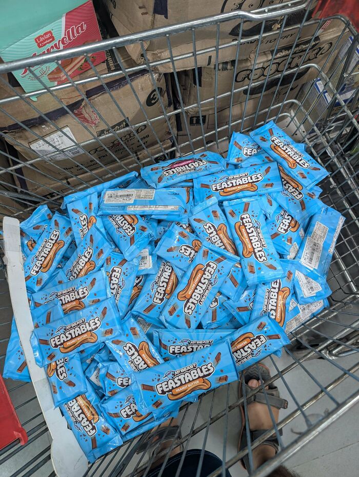 A shopping cart full of Feastables chocolate bars, showing bulk purchasing in modern consumerism.