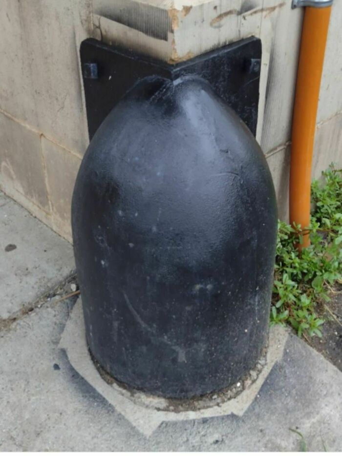 Black rounded metal object attached to a corner wall, one of the disturbing and weird things found in abandoned homes.