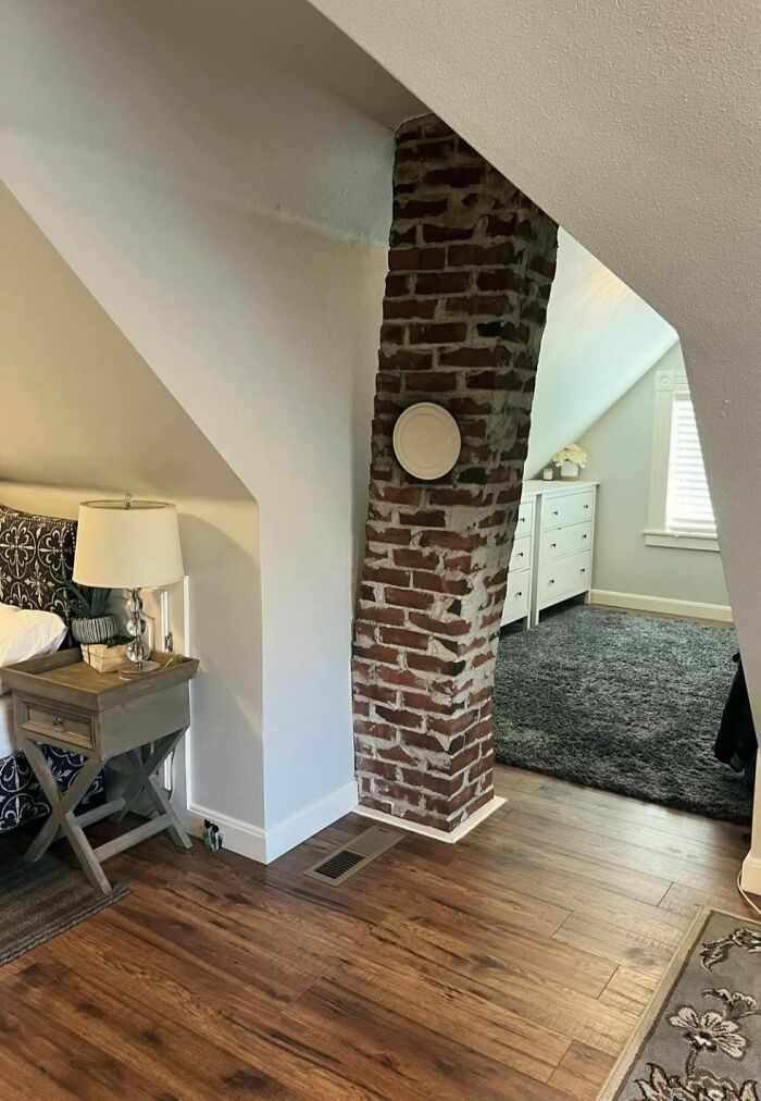 Cozy bedroom with exposed brick chimney in a home showing disturbing and weird things found in abandoned places.