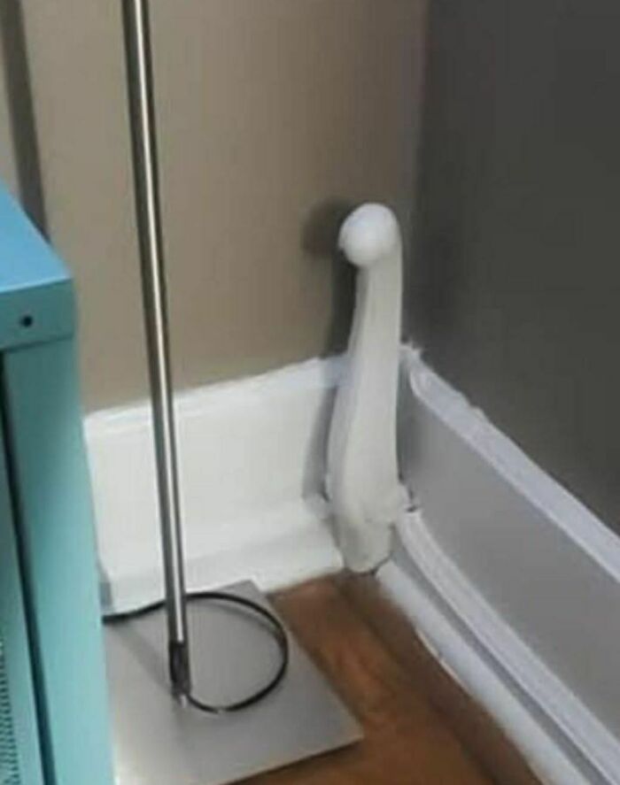 Corner of a room with a floor lamp and a strangely shaped white pipe resembling a weird thing found in abandoned homes