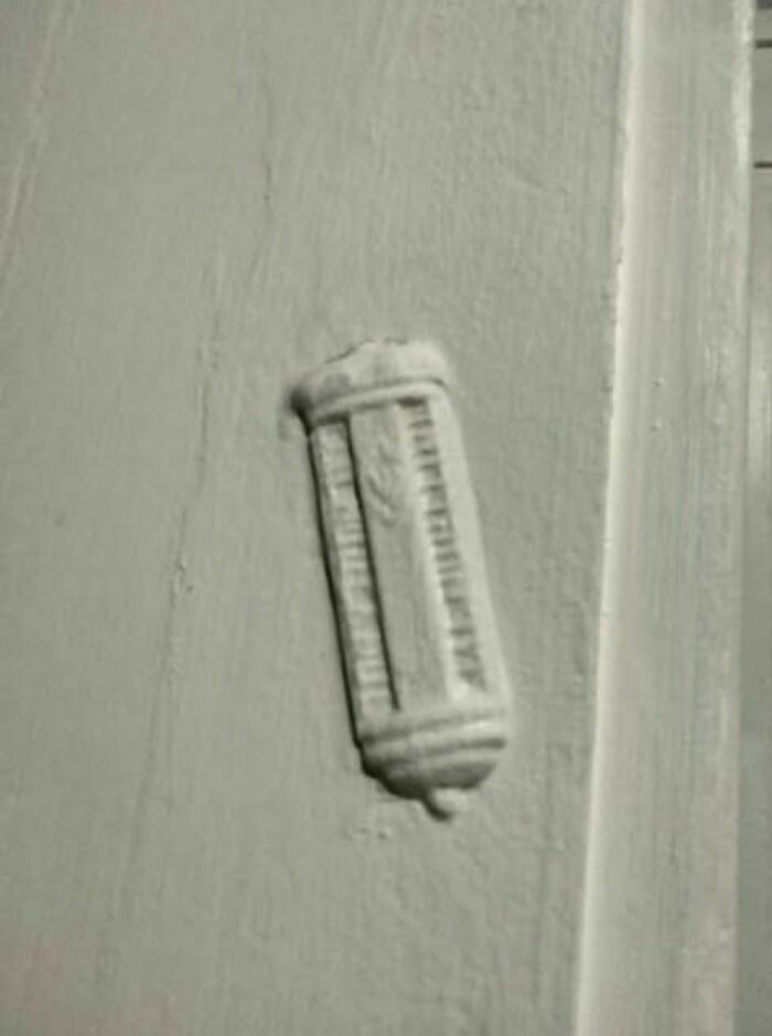 White wall with a small, vintage device embedded, one of the disturbing and weird things found in abandoned homes.