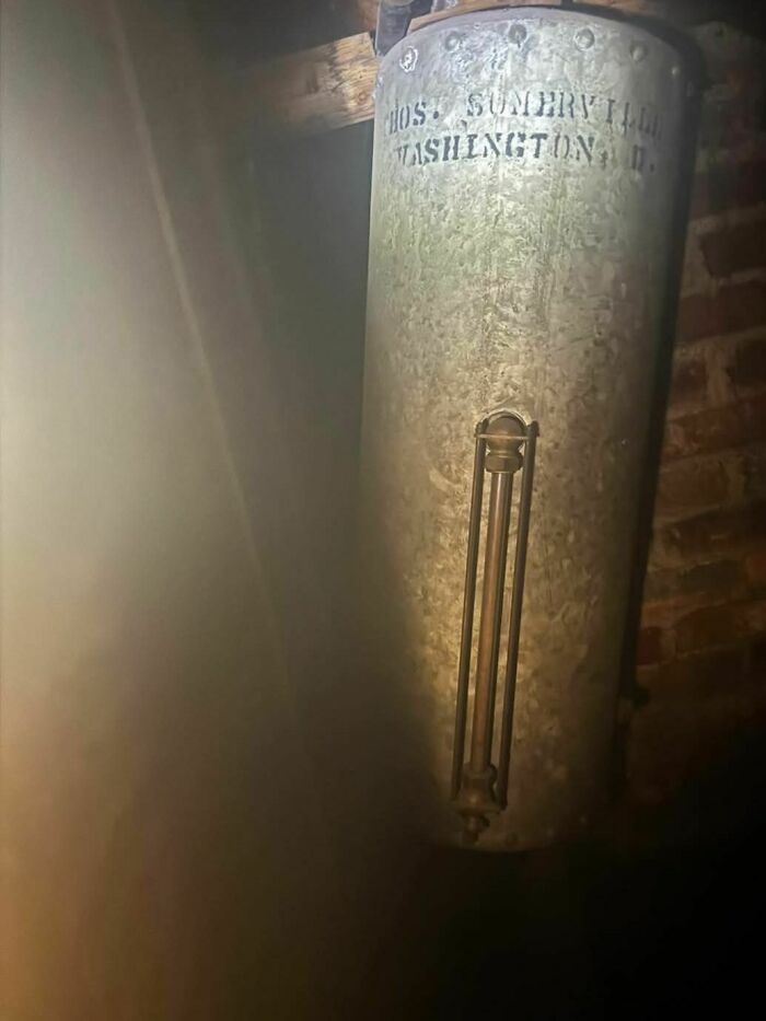 Old rusty boiler in a dark, abandoned home showing disturbing and weird forgotten household items.