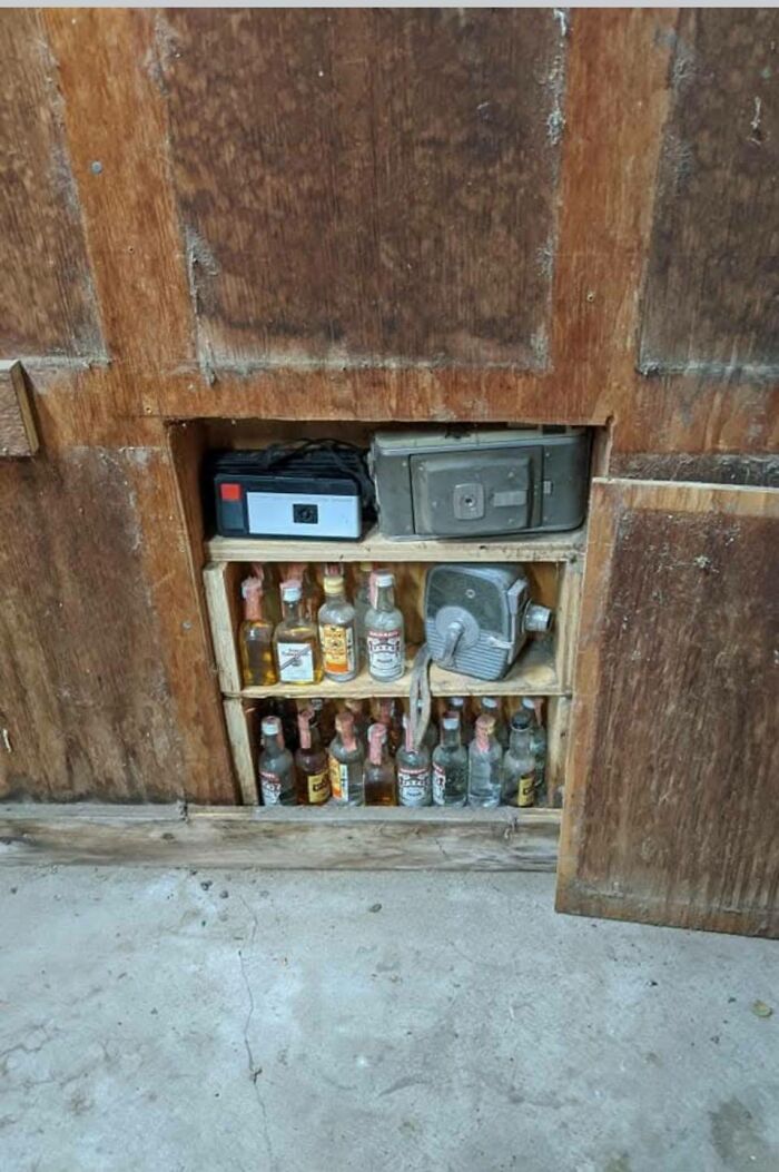 Old hidden cabinet with dusty vintage liquor bottles and an antique safe, found in an abandoned home, weird things discovered.