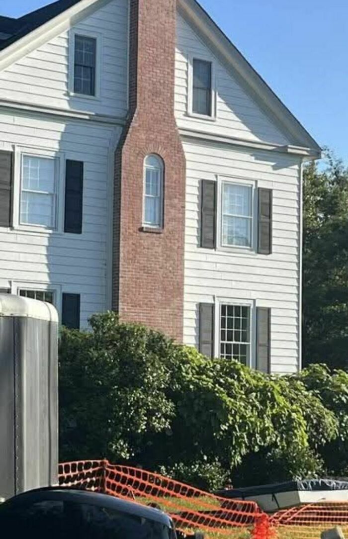White house with a brick chimney featuring an oddly placed narrow window, a disturbing and weird thing found in abandoned homes.
