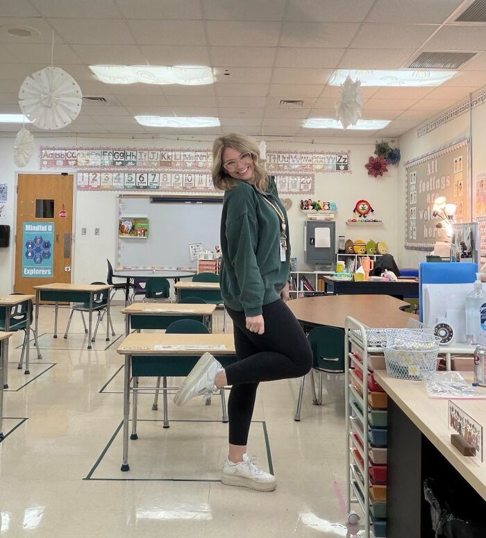 Woman in a classroom smiling and posing confidently, representing ladies who chose power tools and lab coats careers.