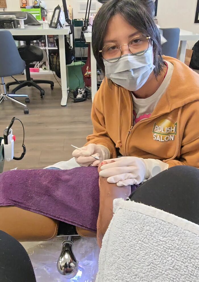 Woman wearing a mask and gloves giving a pedicure at a nail salon, representing ladies choosing power tools and lab coats.