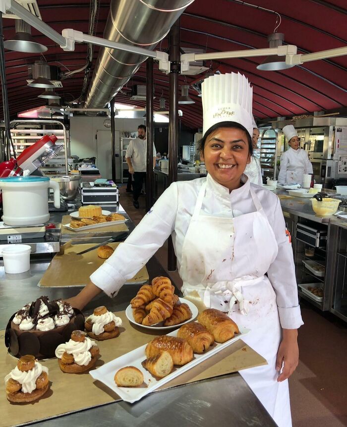 Female pastry chef in a kitchen showcasing baked goods, representing ladies who chose power tools and lab coats careers.