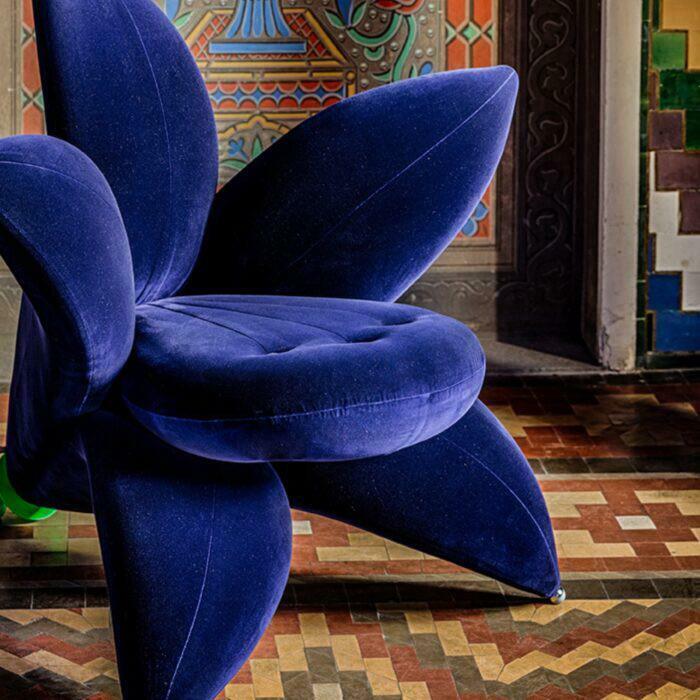 A unique blue flower-shaped chair, a home decor project, adds a vibrant touch to a room with patterned walls.