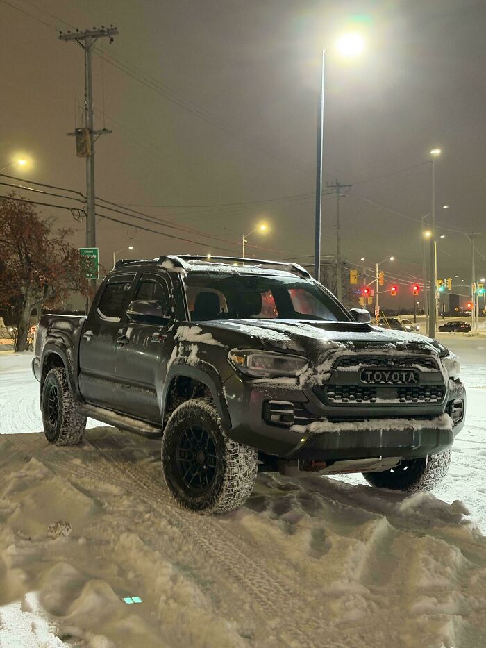 A black Toyota pickup truck covered in snow at night. This "Buy It For Life" purchase still looks great.