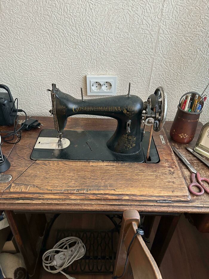 A vintage black sewing machine on a rustic wooden table, an example of a Buy It For Life purchase.