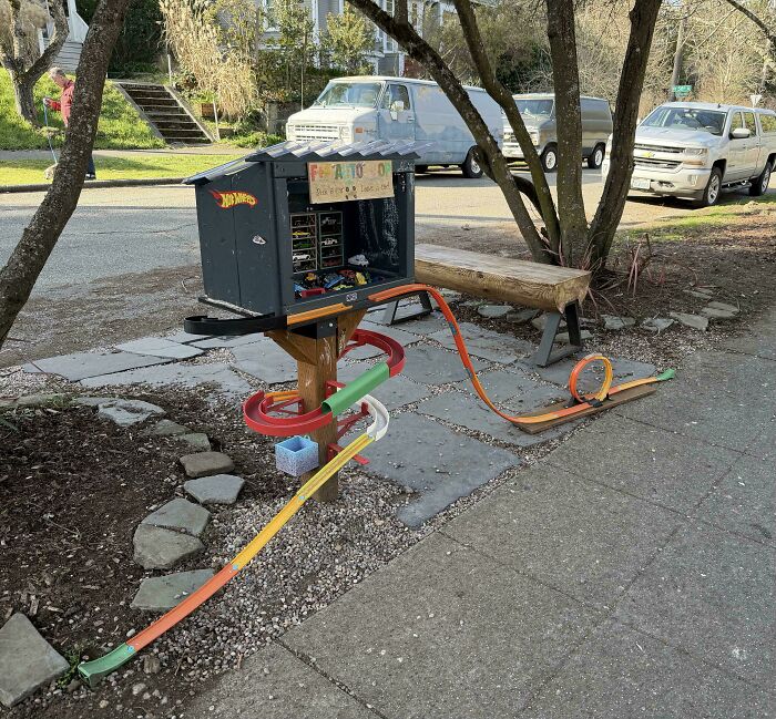 Mildly interesting pictures of a creative Hot Wheels track set up outdoors, flowing from a small house.