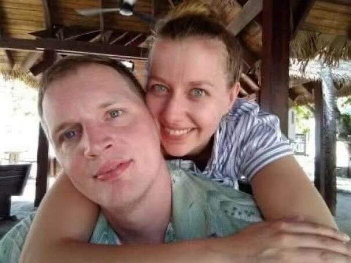 Couple smiling and embracing indoors under wooden roof capturing morbid curiosity moments
