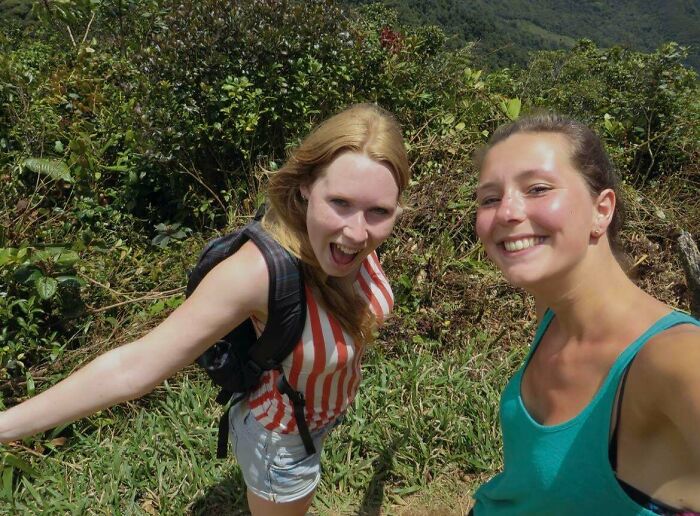 Two women hiking outdoors in nature with lush greenery around during morbid curiosity exploration