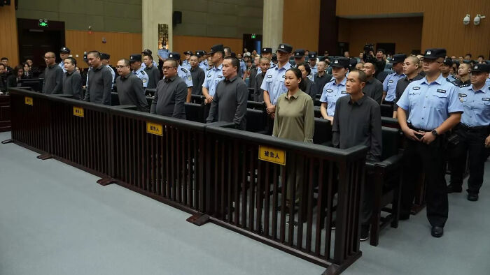 Defendants standing in courtroom with police officers morbid curiosity stories