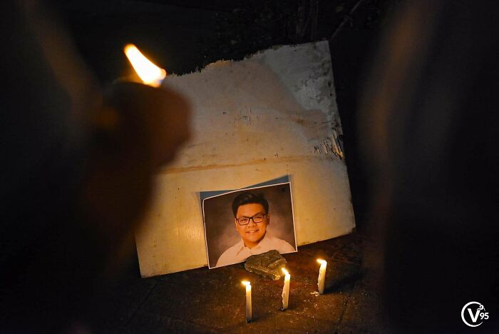 Candles lit in front of a photo during vigil morbid curiosity stories