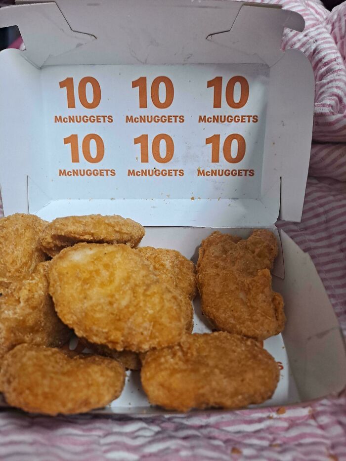 An open McDonald's McNuggets box filled with chicken nuggets, featuring '10 McNUGGETS' printed multiple times, a baffling image.