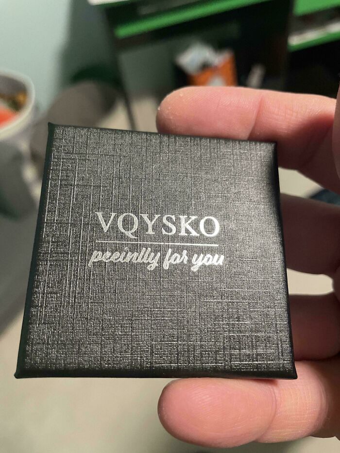 A hand holding a small black gift box with the brand name VQYSKO and the text 'pecinlly for you,' one of the baffling images.