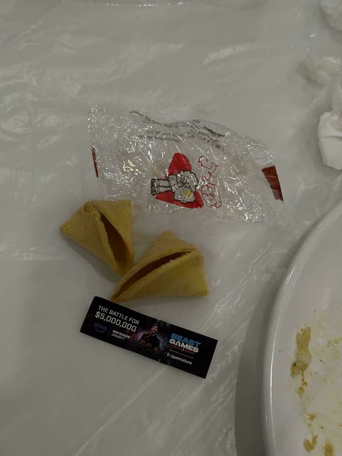 A baffling image showing two empty fortune cookies and a small wrapper with a toy inside.