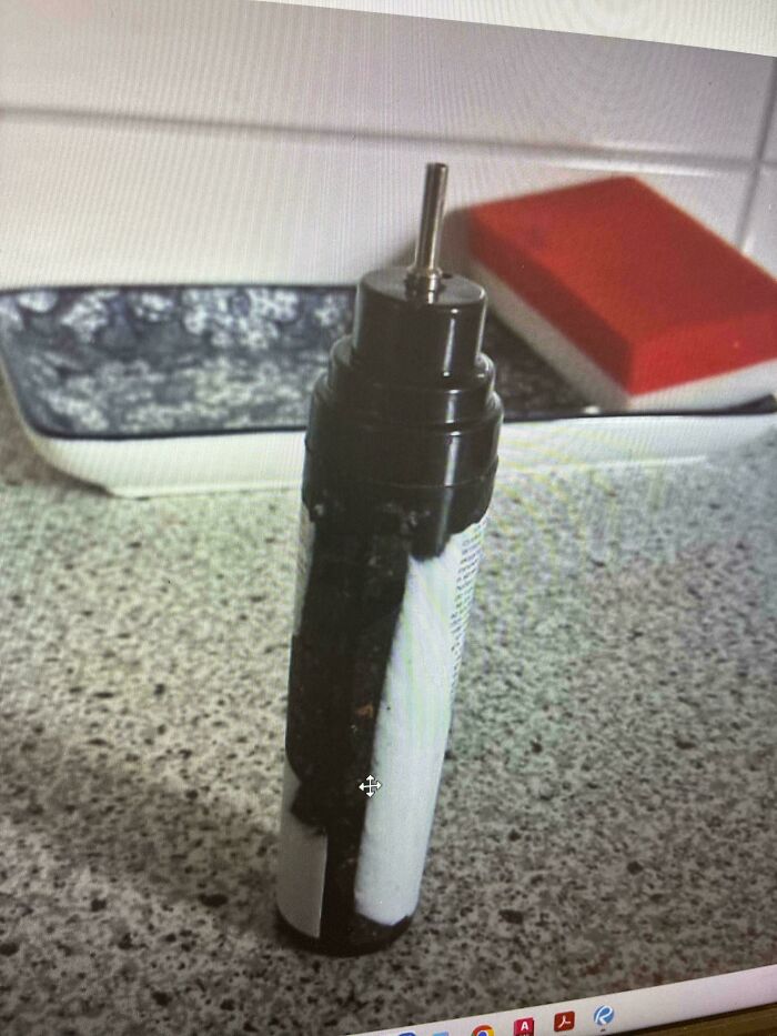 A baffling image of a black and white bottle with a metal nozzle, a perplexing object seeking internet answers.