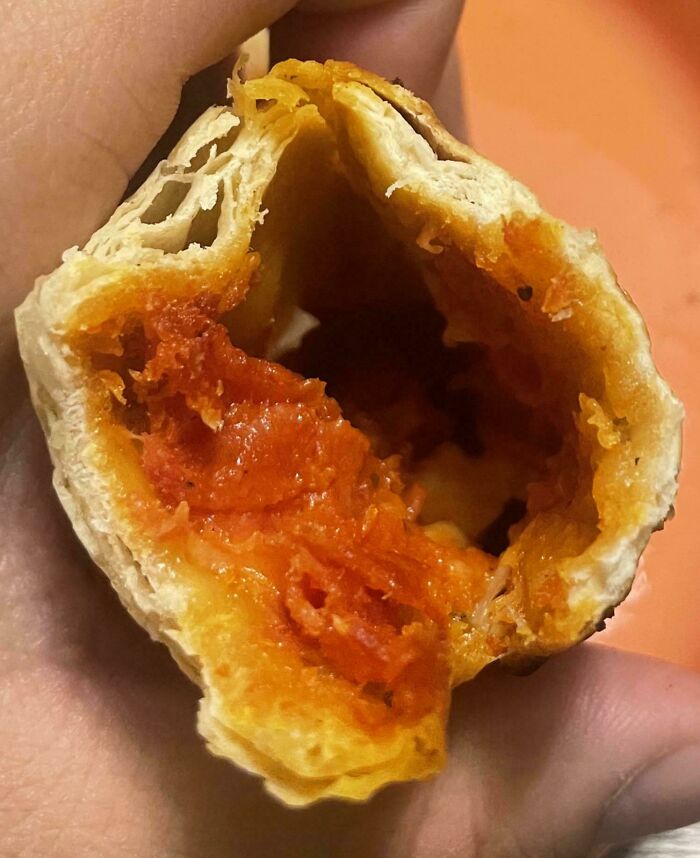 Partially eaten pizza roll showing hollow interior with little filling inside