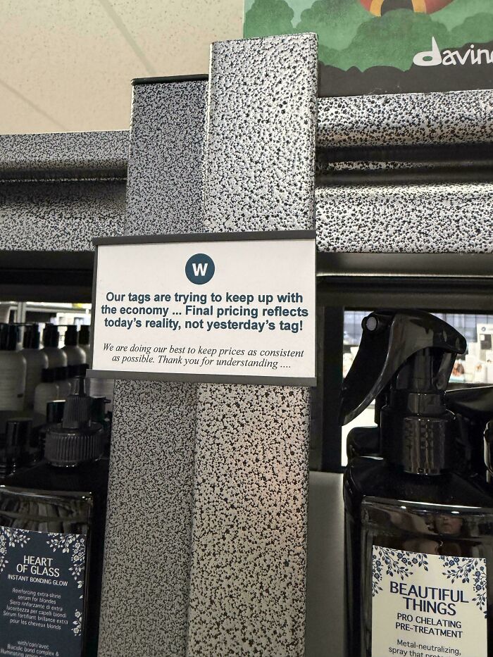 Store sign explaining price tags reflect current pricing, not old prices