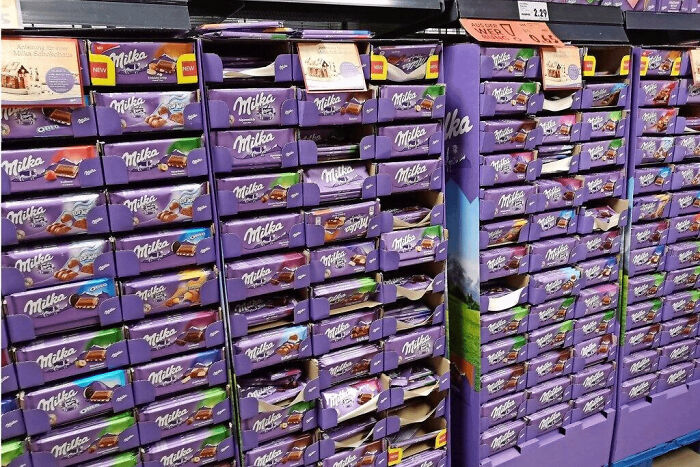 Large store display of Milka chocolate bars stacked on shelves