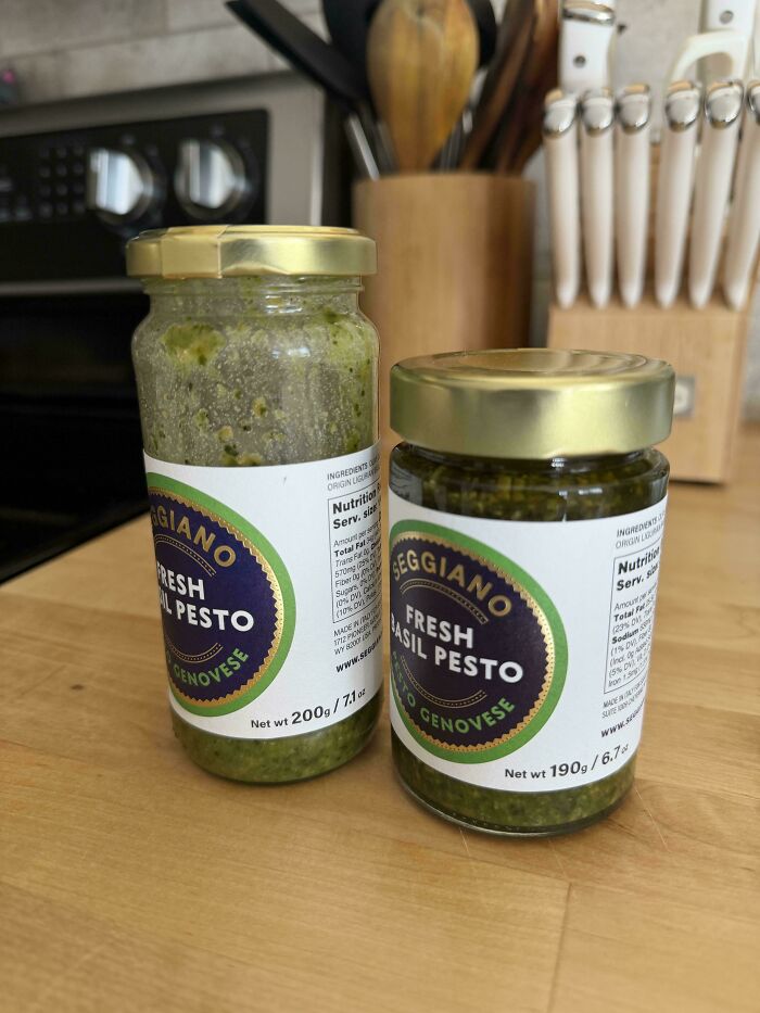 Two jars of Seggiano fresh basil pesto with different jar sizes on kitchen counter