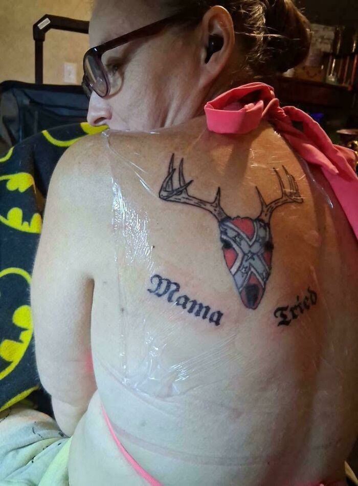 Tattoo fail on back with deer head and text mama tried wrapped in plastic