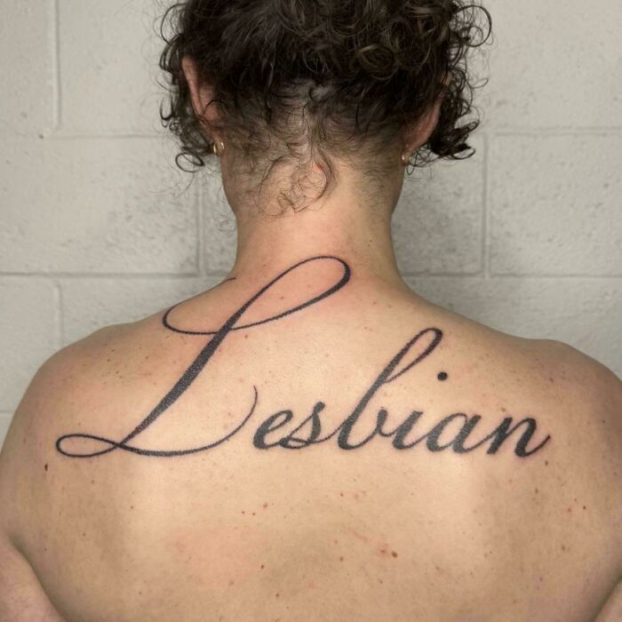 Back tattoo fail with large cursive word lesbian inked on upper back