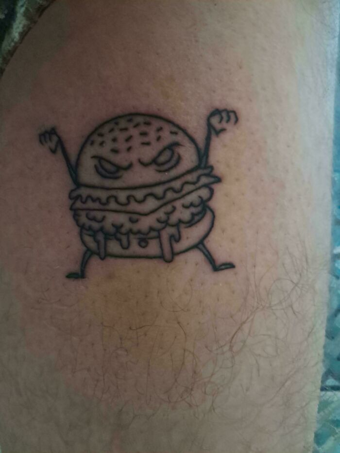 Angry cartoon burger tattoo fail on leg area