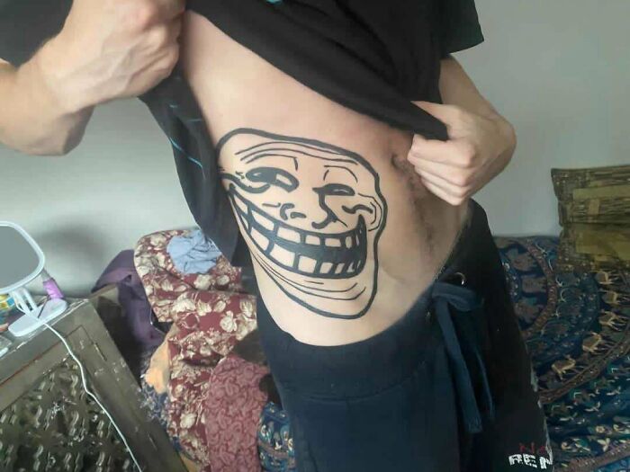 Side tattoo fail featuring poorly done trolling face