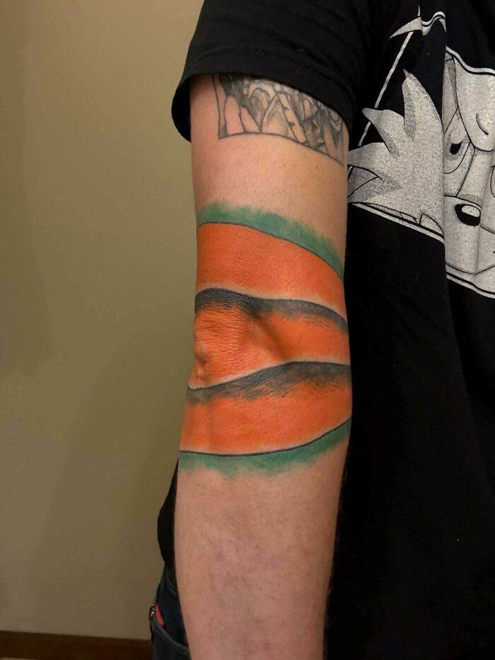 Bright orange and green tattoo fail on person's arm