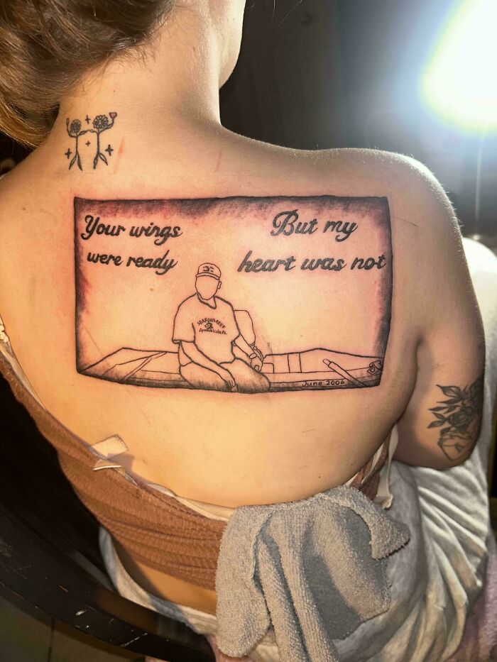 Tattoo fail of a poorly drawn memorial image with missing facial details and text on back