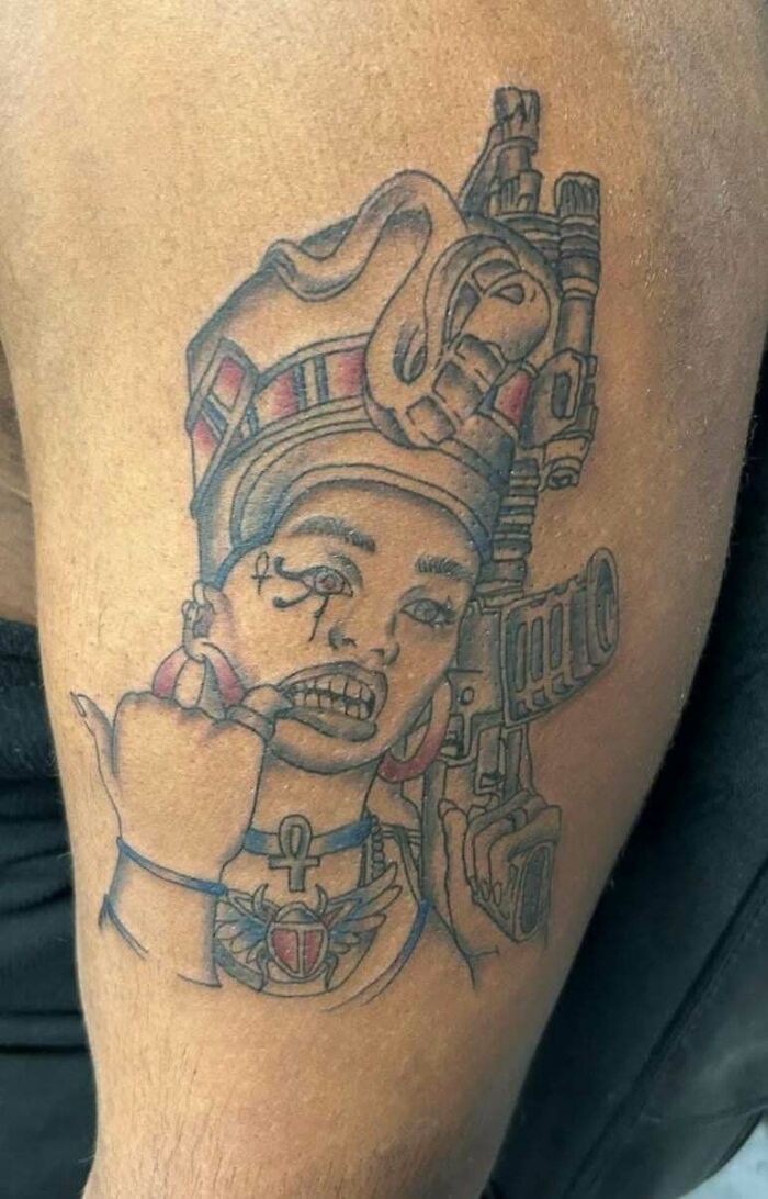 Tattoo of person with crown and gun with distorted features tattoo fail