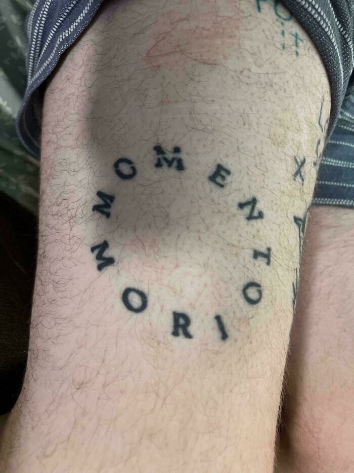 Circular tattoo with misaligned text spelling moment mori tattoo fails