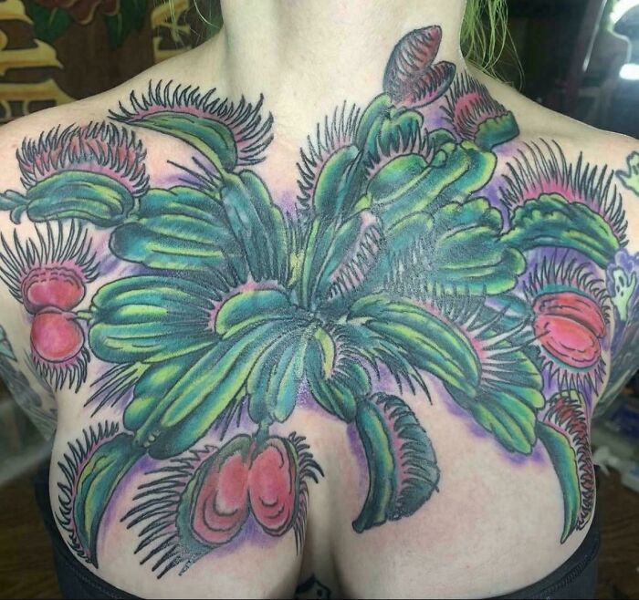 large colorful Venus flytrap tattoo across upper chest