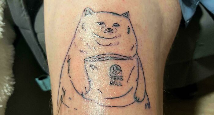 Funny tattoo fail of a poorly drawn dog holding a Taco Bell bag