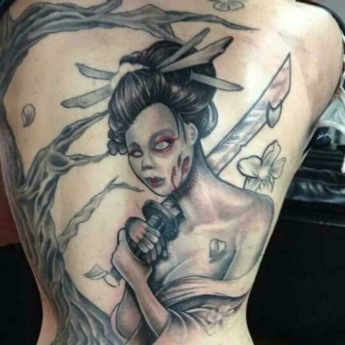 Tattoo fail of a woman holding a katana sword with exaggerated features