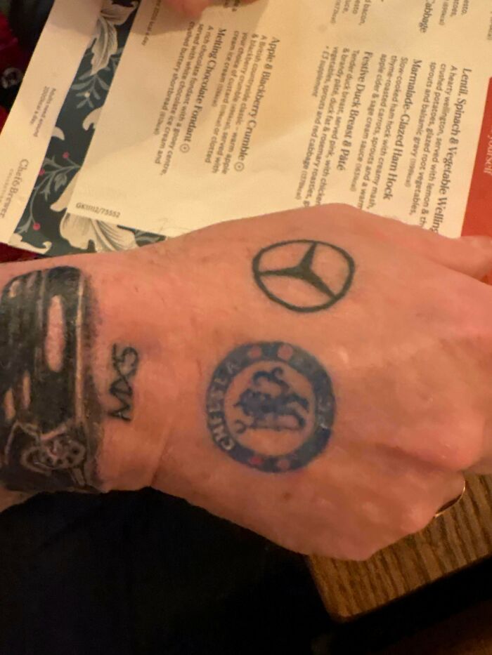 Hand tattoo fail combining Mercedes logo and other symbols