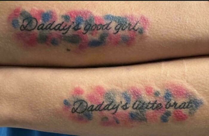 Tattoo fail with blurry script reading daddys good girls on forearms