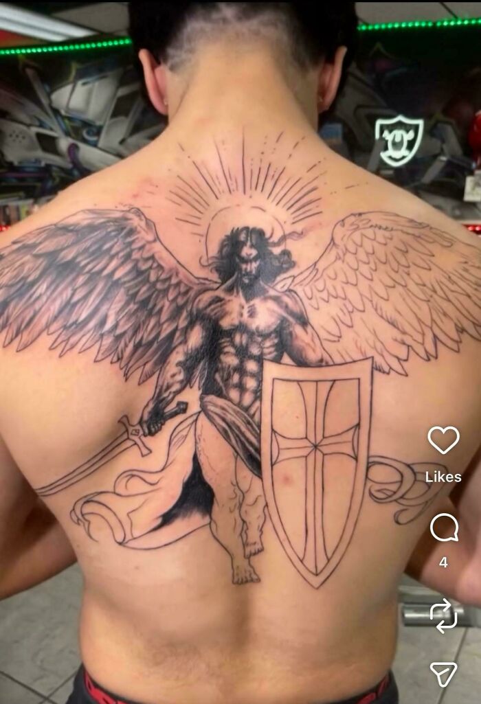 Incomplete winged warrior tattoo fail with uneven shading on man's back