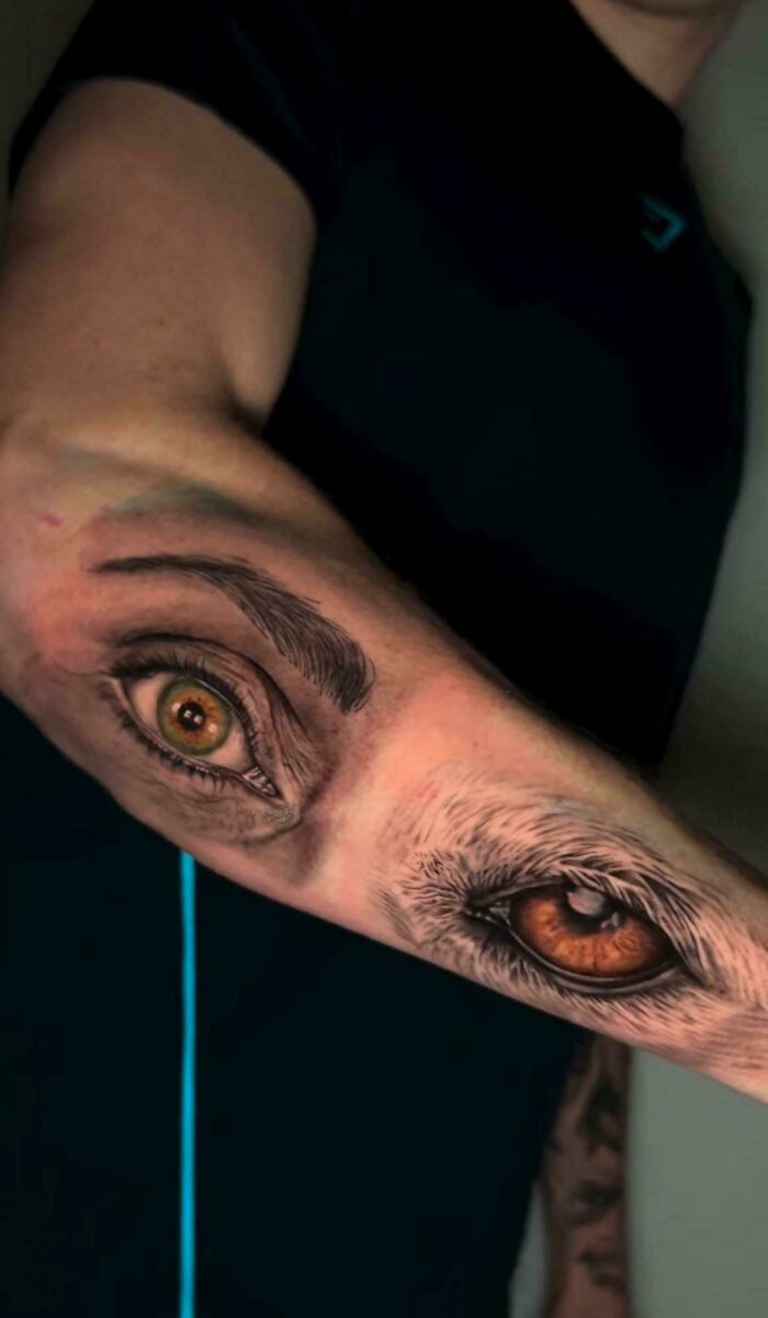 Unusual tattoo fail featuring mismatched realistic human and animal eyes on forearm